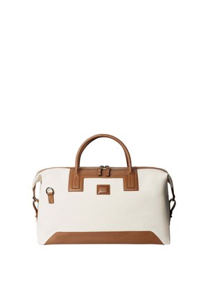 Canvas duffle bag in cream with brown leather accents, featuring dual top handles, a zip closure, and a detachable shoulder strap.