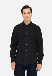 Camicia nera a maniche lunghe con bottoni, realizzata in tessuto texturizzato, con colletto e bottoni argentati lungo il davanti.