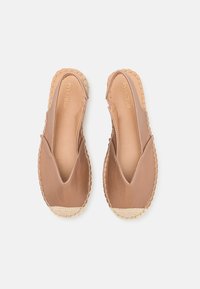 Hnědé kožené espadrilky s tkaným juteovým špičkou, elastickými bočními panely a prošívanými detaily podél okrajů. Ploché podešve a minimalistický design.