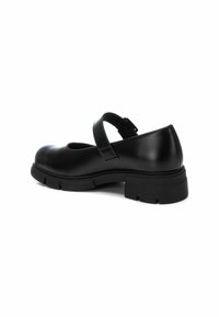 Zapato Mary Jane de cuero negro con punta redonda, correa ajustable y suela de goma gruesa con un diseño de banda de rodadura.
