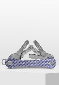 Multiverktyg med komponenter i rostfritt stål och ett lila texturerat handtag. Har flera vikbara verktyg, inklusive blad och skruvmejslar.