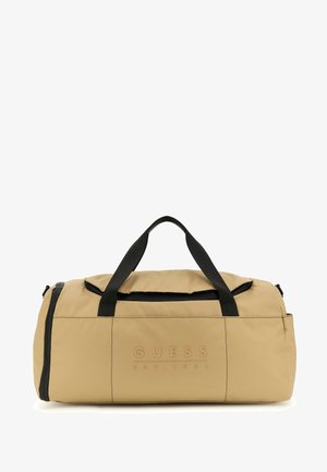 Beżowa torba podróżna wykonana z nylonu z czarnymi akcentami, z widocznym logo z przodu, podwójnymi uchwytami na górze oraz zamykanym głównym przedziałem.