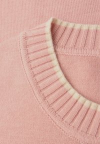 Maglione a maglia rosa chiaro con colletto a coste caratterizzato da un accento crema. Texture morbida con una finitura liscia, che mette in mostra una lavorazione dettagliata.