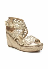 Sandalia cuña dorada con detalles trenzados y punta abierta. Presenta un upper texturizado, correa ajustable y suela de plataforma envuelta en yute.