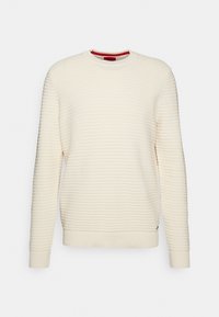 Pull en maille côtelée couleur crème avec manches longues et col rond, présenté sur un fond blanc.