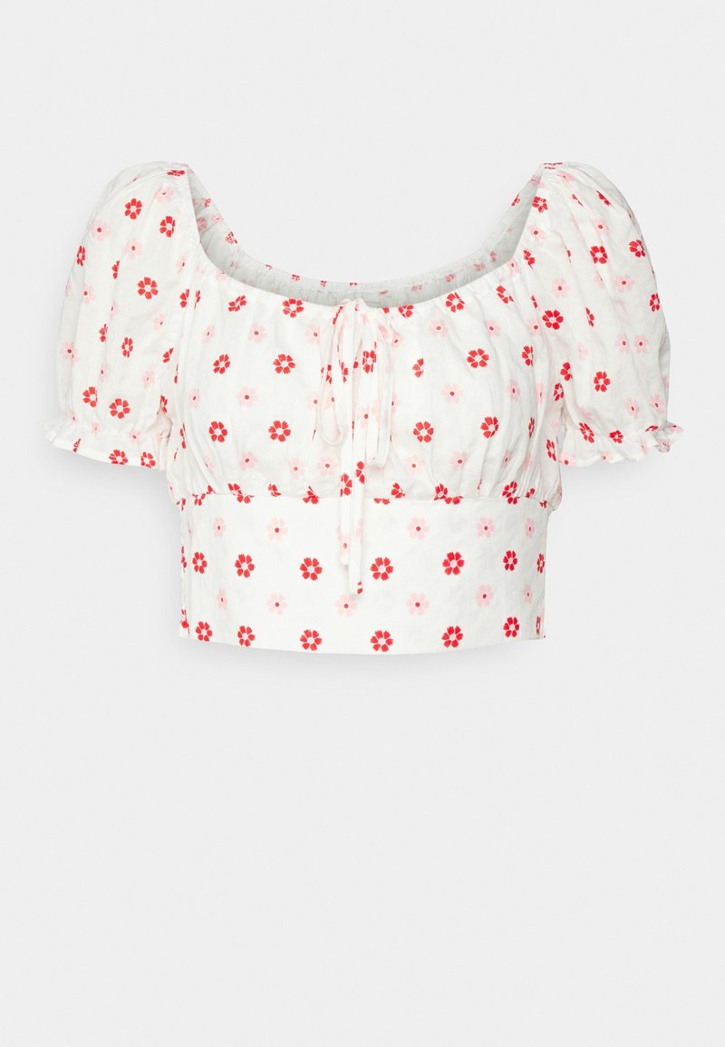 Top corto bianco con maniche a sbuffo, scollo rotondo e stampa floreale in rosso e rosa. Il materiale sembra leggero e con una texture.