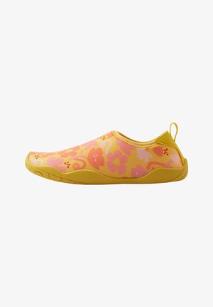 Żółte buty wodne z różowymi kwiatowymi wzorami i gładkim materiałem. Model wsuwany z elastyczną podeszwą i małym uchwytem z tyłu, co ułatwia zakładanie.