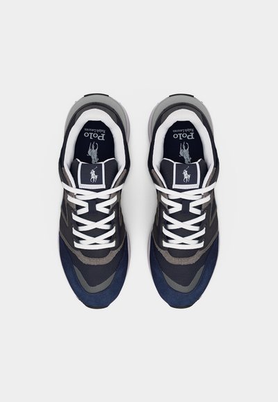 Ζευγάρι αθλητικών παπουτσιών Polo Ralph Lauren σε ναυτικό μπλε, γκρι και μαύρο με λευκά κορδόνια, φωτογραφημένα από πάνω σε απλό ανοιχτό φόντο.