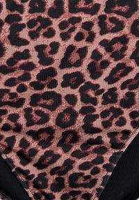 Tkanina s uzorkom leoparda u nijansama smeđe i crne, s glatkom teksturom i blagim sjajem, te kontrastnim rubovima.