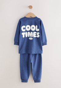Niebieski bawełniany komplet dwuczęściowy składający się z bluzy z długim rękawem z napisem "COOL TIMES" w grubych białych literach oraz dopasowanych spodni dresowych z elastycznymi mankietami.