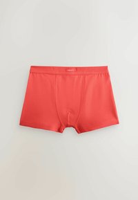 Boxers rouges pour hommes avec coutures plates et ceinture élastique portant la mention « NEXT » posés à plat sur un fond blanc.