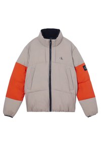 Puffová bunda ve světle béžové barvě s oranžovým rukávem, vysokým límcem, zapínáním na zip a dvěma předními kapsami. Na hrudi se nachází logo.