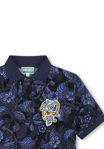 Polo shirt met een marineblauw bloemenpatroon, voorzien van blauwe bloemen en een gele tijgerlogo patch op de borst. Zacht katoen.