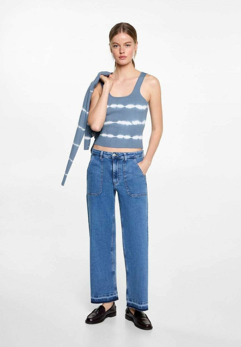 Žebrovaný modrý crop top s bílým tie-dye vzorem, spárovaný s vysokými širokými denimovými kalhotami s předními kapsami a zakončením s manžetou.