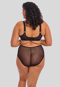 Ensemble de soutien-gorge noir et de lingerie haute taille transparente. Le soutien-gorge dispose de bretelles ajustables et d'une fermeture à crochets. Texture lisse et design minimal.
