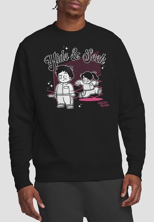 Schwarzer Pullover mit einem grafischen Design, das zwei Comic-Figuren zeigt, die Verstecken spielen, Text "Verstecken" und Sterne.