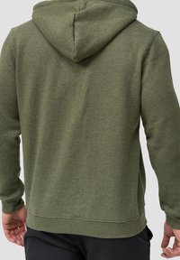 Sudadera verde con una textura suave, que cuenta con capucha con cordón, puños y dobladillo acanalados, y un ajuste relajado. Sin gráficos ni patrones visibles.