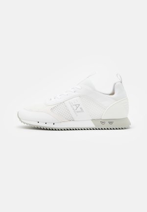 Witte lage sneaker met mesh- en leren panelen, EA7-logo aan de zijkant, geribbelde zool en lusjes op de tong en hiel.