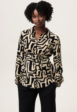 Zwart en beige gestreepte blouse met lange mouwen, kraag, gestrikte taille, knoopsluiting aan de voorkant en elastische manchetten; gemaakt van een gladde stof.
