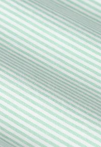 Close-up van stof met dunne, gelijkmatig verdeelde groene en witte horizontale strepen en een gestructureerd geweven patroon.