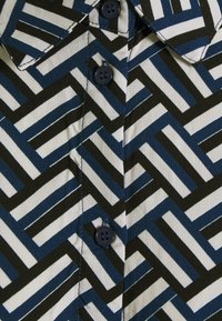 Korte mouw shirt van katoen, met een geometrisch patroon van zwarte, blauwe en witte strepen, met knoopsluiting en kraag.