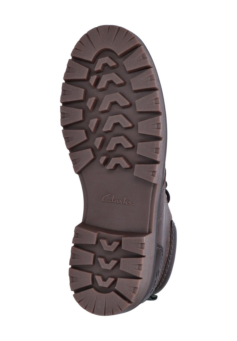 Semelle d'une botte Clarks marron avec des motifs de semelle profonds pour une traction sur fond blanc.