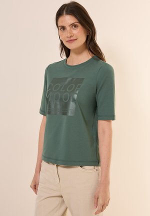 Grøn bomulds t-shirt med korte ærmer og rund halsudskæring. Har et blankt sort grafisk tekstdesign på forsiden. Glat tekstur.