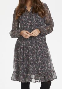 Blumenkleid aus dunklem Stoff mit durchsichtigen langen Ärmeln, Knopfleiste und volantrundem Saum. Das Kleid weist ein gemischtes Muster aus rosa und blauen Blumen auf.