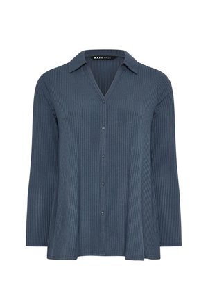 Camisa azul marino de canalé, con cuello en V y mangas largas. Presenta un cuello estructurado y seis botones en la parte delantera. Textura suave.