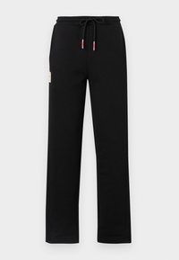 Pantalon de survêtement noir en mélange de coton, avec une ceinture élastique à cordon et des poches latérales. Sans motifs, équipement minimal.