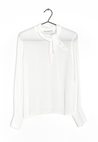 Hvid, gennemsigtig bluse med lange ærmer, bindesnor ved halsen, knapdetaljer og manchetærmer. Glat tekstur med et let, svævende design.
