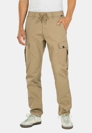 Pantalones cargo beige con cintura ajustable, dos bolsillos laterales y dos bolsillos cargo en los muslos, fabricados con una tela texturizada.
