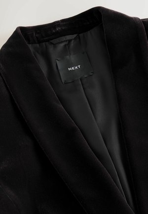 Must must blazer pehmea tekstuuriga, satiinvooder, laiad kraed ja sildiga, millel on kirjas "NEXT" seestpoolt.