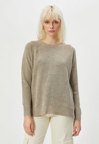 Beige gestrickter Pullover mit rundem Halsausschnitt, langen Ärmeln und strukturiertem Muster. Weiches Material mit leichter Rippenstruktur und lockerer Passform.