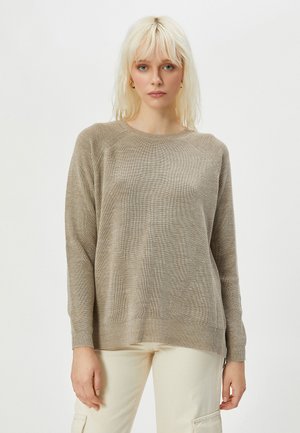 Beige neulepusero, jossa on pyöreä pääntie, pitkät hihat ja teksturoitu kuvio. Pehmeä materiaali, jossa on hieno ribbaus ja rento istuvuus.