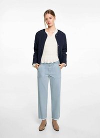 Námornícky prešívaný bomber sako, biela textúrovaná blúzka s riaseným výstrihom, svetlomodré široké nohavice a pieskové členkové čižmy.