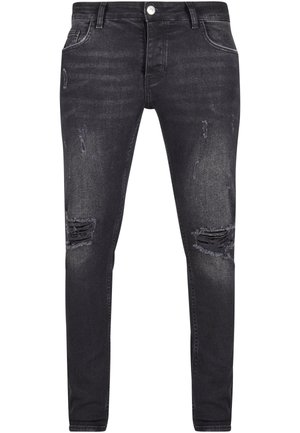 Černé denimové džíny s úzkým střihem, s poškozenými detaily a trhanými místy na přední části. Vybaveny zapínáním na knoflík a zip.