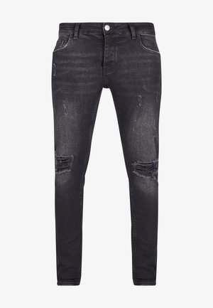 Zwarte denim jeans met een slim fit, voorzien van versleten details en gescheurde patches aan de voorkant. Voorzien van een knoop- en ritssluiting.