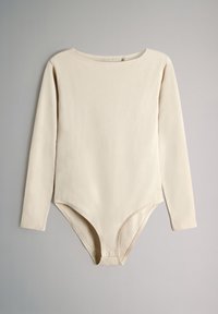 Body z długim rękawem wykonany z miękkiej beżowej tkaniny, z okrągłym dekoltem i zapięciem na napy na dole. Gładka faktura, smukły krój.