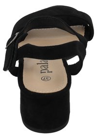 Sandalo platform in suede nero con cinturino regolabile, design aperto sulla punta e tacco solido. L'interno presenta una soletta beige con logo del marchio stampato.