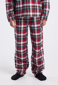 Red and green plaid flannel pajama set with long sleeves and loose-fitting pants. Material appears soft with a smooth texture.