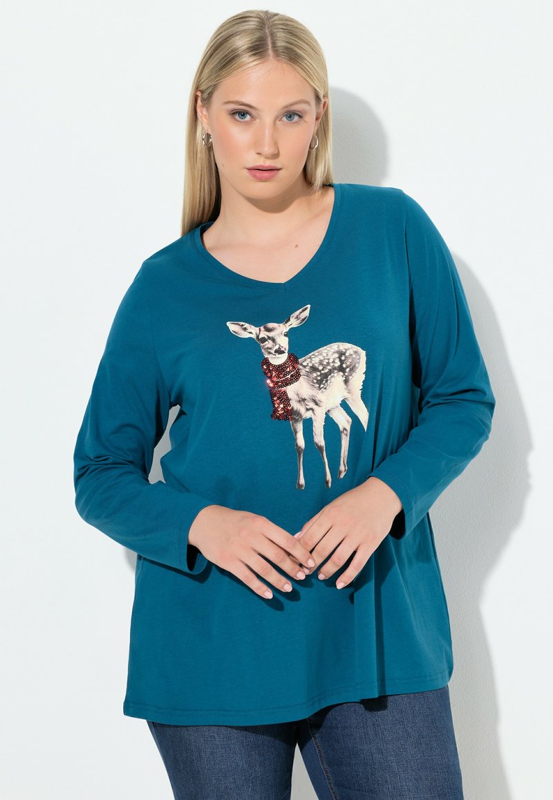 Tassenvor langer Ärmel Shirt in Türkis mit einem Hirsch-Graphic und einem rotem Pailletten-Schal. Aus weichem Stoff, mit lockerer Passform und V-Ausschnitt.