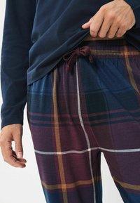 Die Baumwollpyjamahosen verfügen über ein karriertes Muster in Weinrot, Marineblau und Grün, mit weißen und goldenen Akzenten. Elastischer Bund mit Kordelzug.