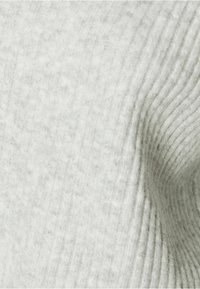 Ljusgrå räfflad tygtextur med en mjuk, något fuzzy yta som har vertikala ränder och subtila variationer i nyanser.