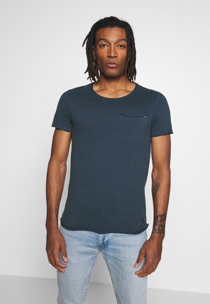 T-shirt blu navy a maniche corte in tessuto morbido, con scollatura rotonda e taschino sul petto. Il design presenta dettagli di cucitura discreti.