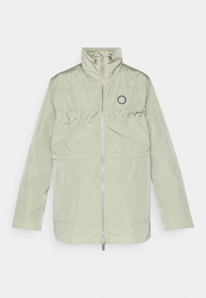 Világoszöld széldzseki könnyű anyagból, magas gallérral, cipzáras záródással és húzott derékrésszel. Kerek logó a mellkason.