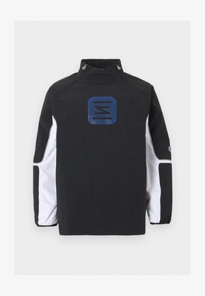 Veste noire à manches longues avec des panneaux blancs sur les manches, col montant avec boutons-pression et logo géométrique bleu centré sur la poitrine.