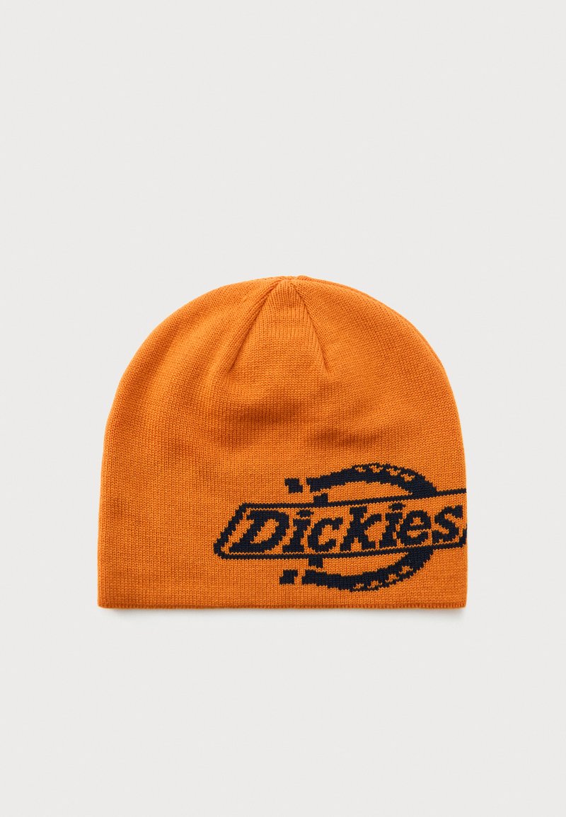 Orange strikket hue med sort "Dickies" logo og delvist cirkulært design på en ensfarvet lys baggrund.