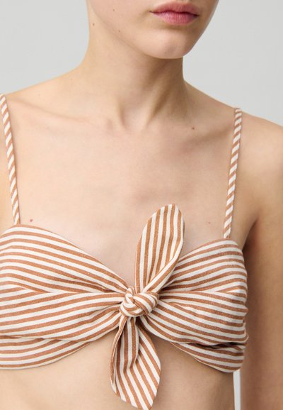 Top de bikini sin tirantes con rayas horizontales marrón y blancas, que presenta un detalle de nudo en la parte delantera y tirantes delgados ajustables.