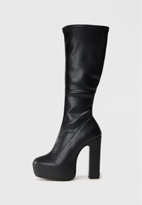 Stivale nero al ginocchio con plateau, punta arrotondata e tacco alto chunky, texture in pelle liscia, senza decorazioni visibili.